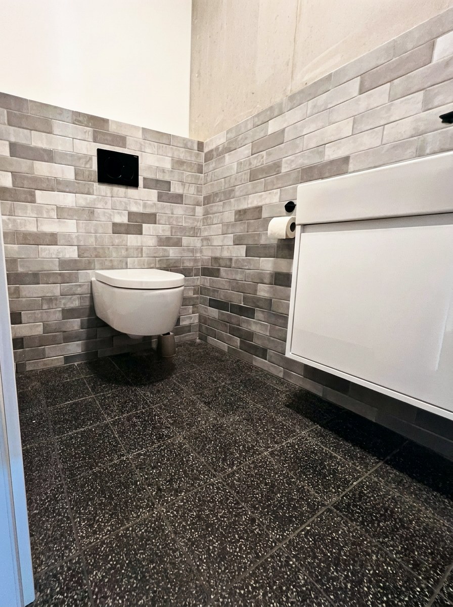 WC mit Riemchen-Wandfliesen und Terrazzo-Boden